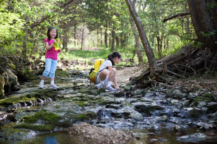 Two children exploring a stream at Runge CNC